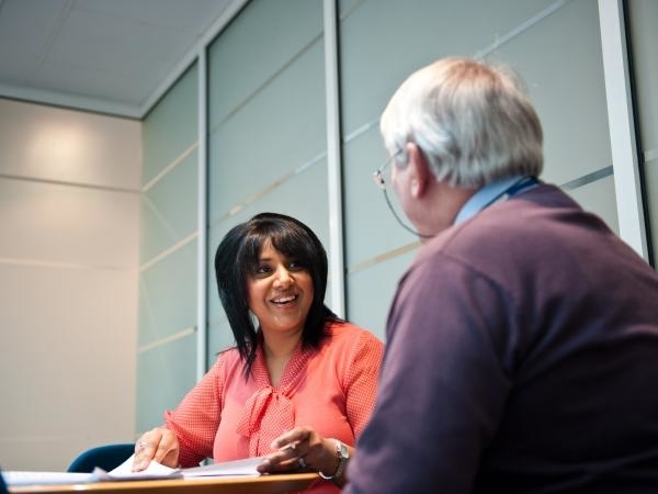 Woman and man talking over desk