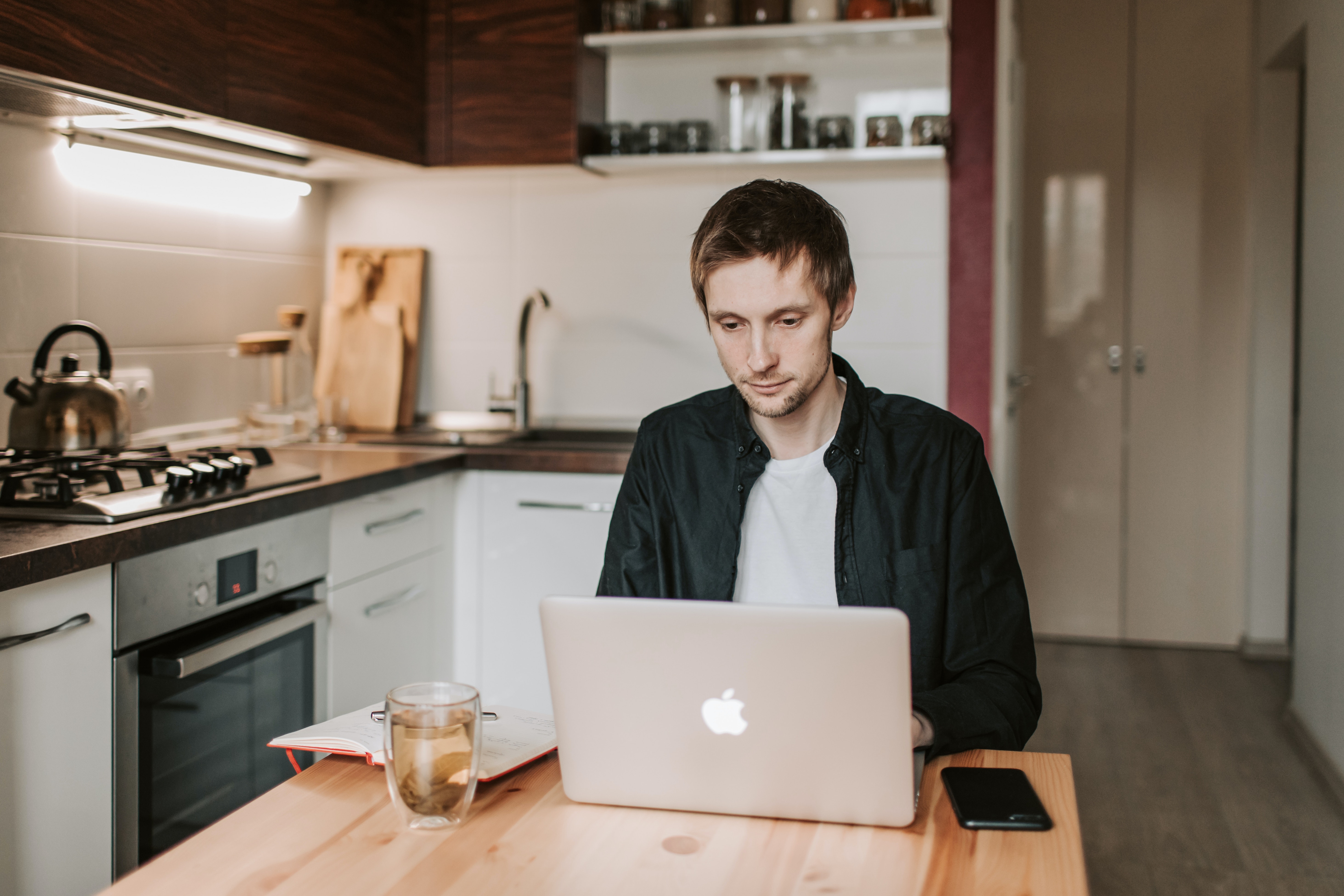 Man working on laptop on kitchen table