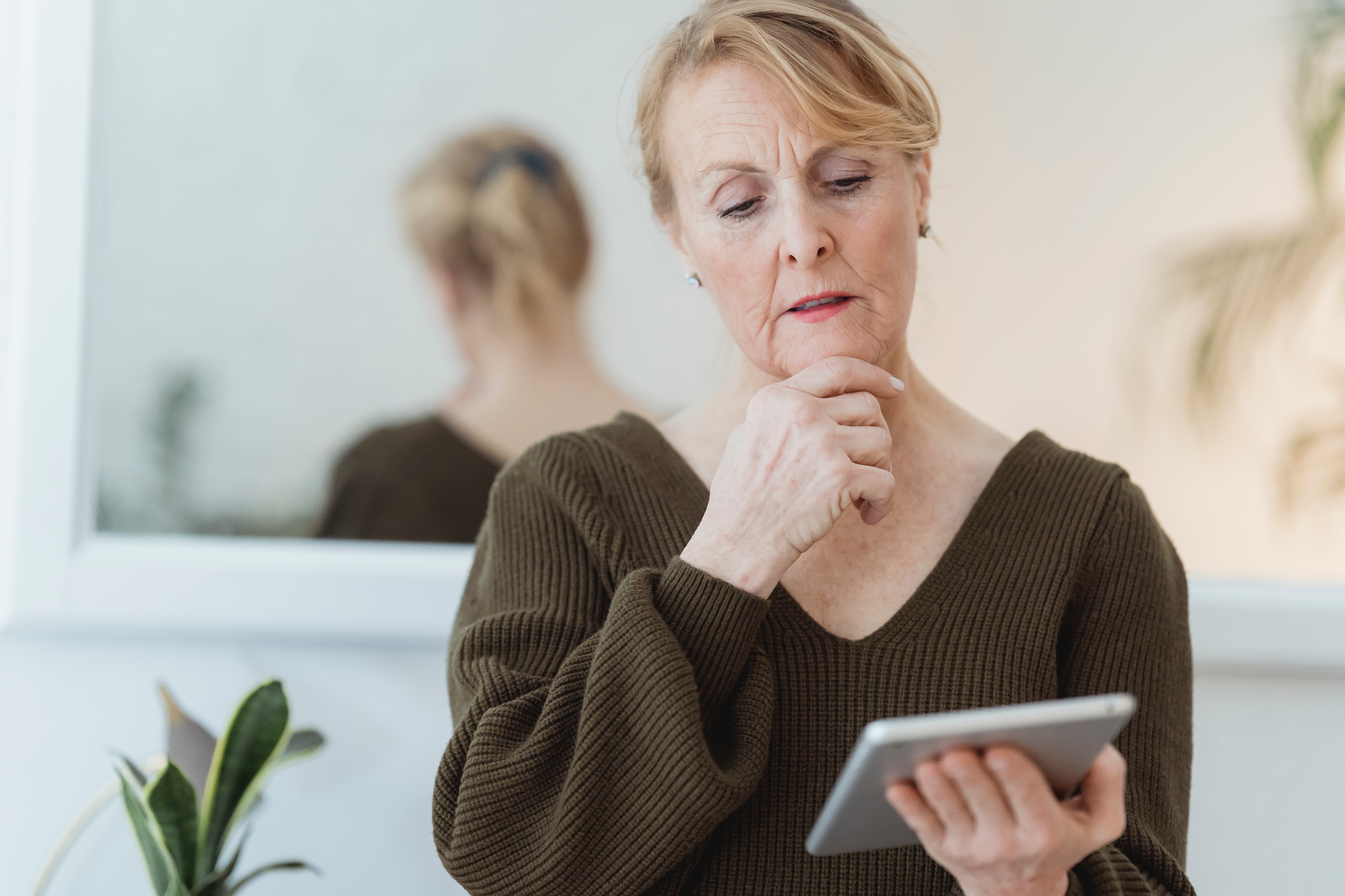 Woman in thought using a tablet