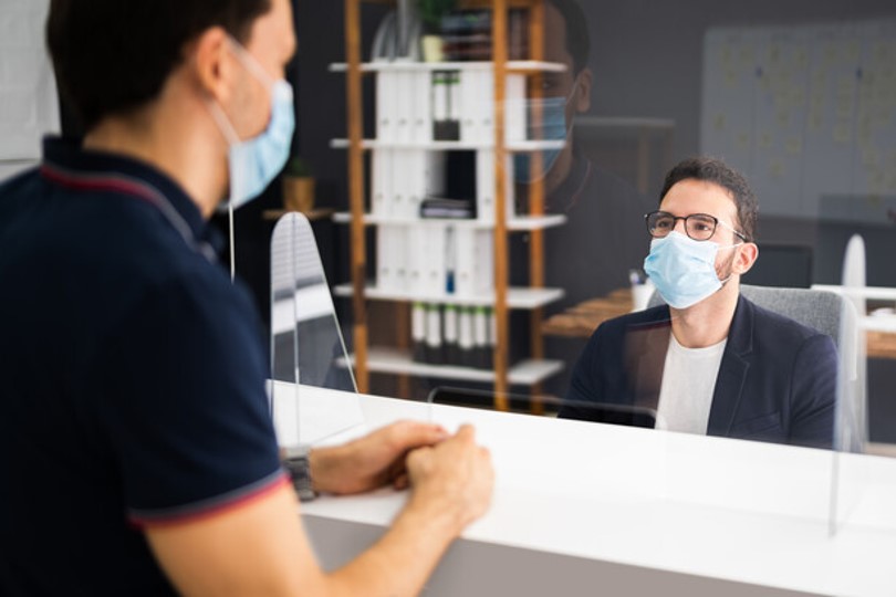 Man checking in for an appointment at a covid safe reception desk